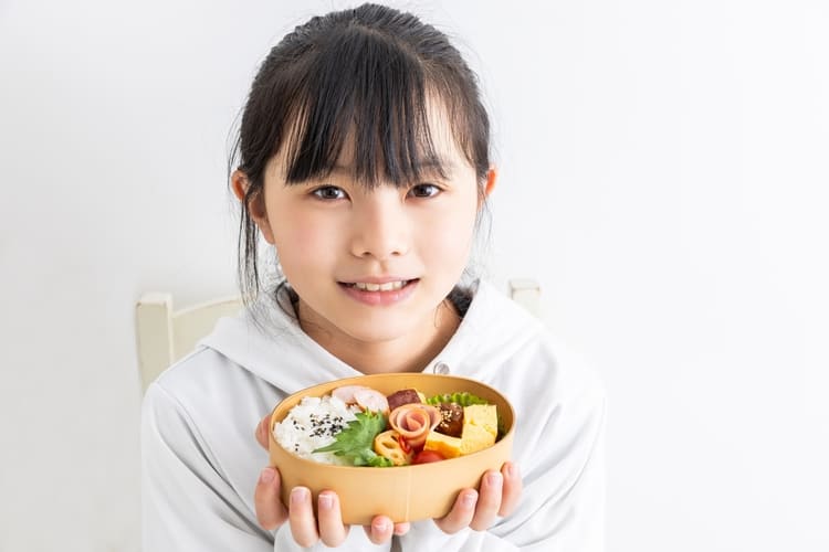 お弁当を持つ笑顔の少女