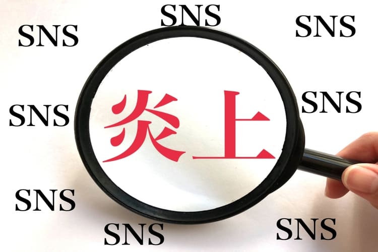  拡大鏡でSNS炎上を確認するイメージ